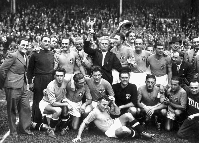 Italiens Nationalmannschaft gewinnt nach einem 4:2 Sieg gegen Ungarn die Fußball-Weltmeisterschaft 1938. (vorne von links : Amadeo Biavati (4th L), coach Vittorio Pozzo holding the trophy, Silvio Piola, Giovanni Ferrari, Gino Colaussi; erste Reihe von links : Ugo Locatelli, Giuseppe Meazza, Alfredo Foni, Pietro Serantoni, Aldo Olivieri, Pietro Rava and Michele Andreolo) / AFP PHOTO / STAFF