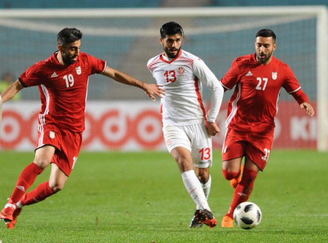 Tunisiens Mittelfeldspieler Ferjani Sassi (Mitte) im neuen weißen Heimtrikot 2018 und Iran's Kaveh Rezaei (L) und Saman Ghoddos (R) beim Testspiel am 23.März 2018. / AFP PHOTO / SALAH HABIBI